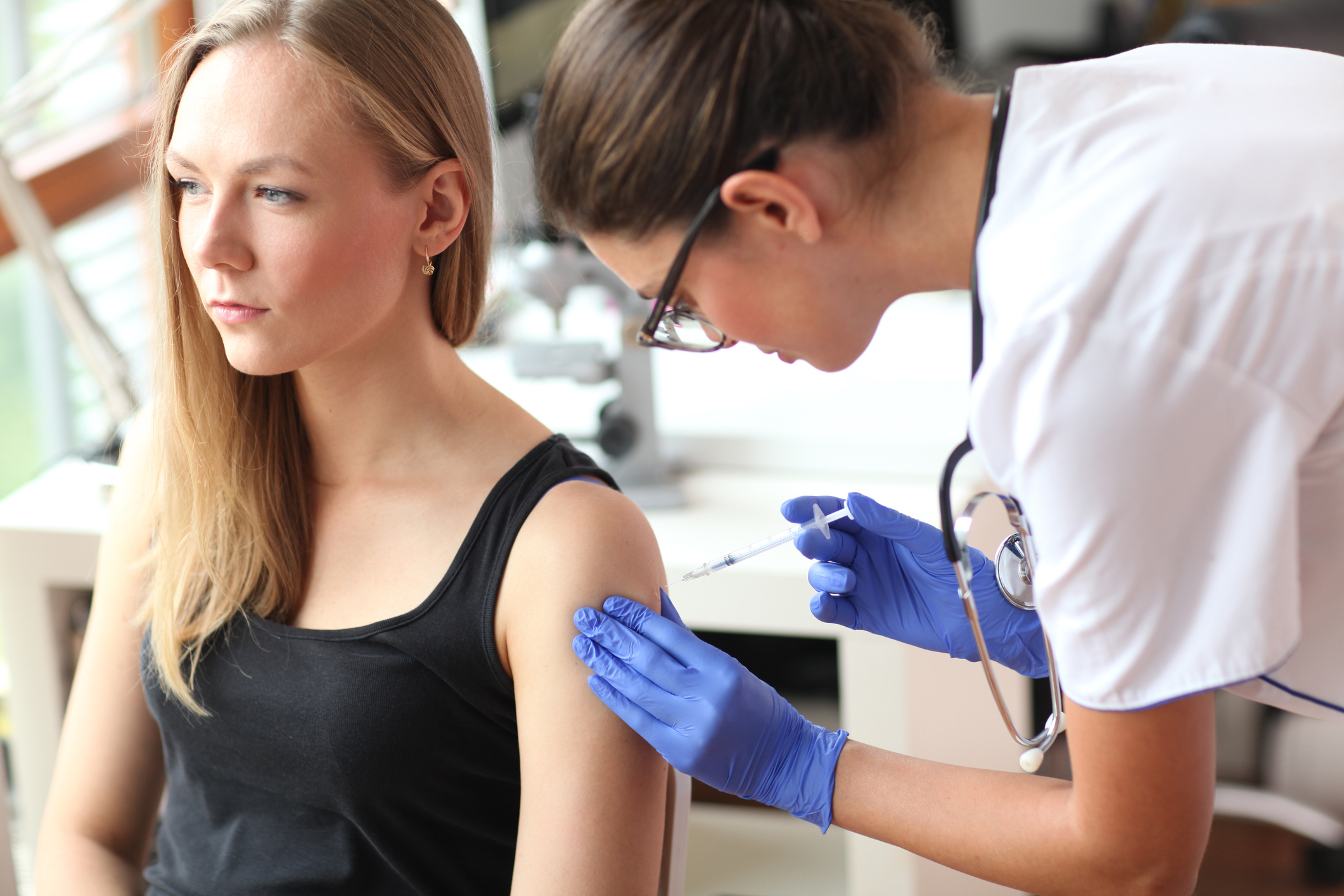 Young doctor giving a patient injection.