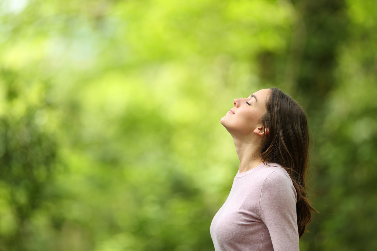 Woman breathing easily outdoors after finding chronic sinusitis relief in Western Massachusetts